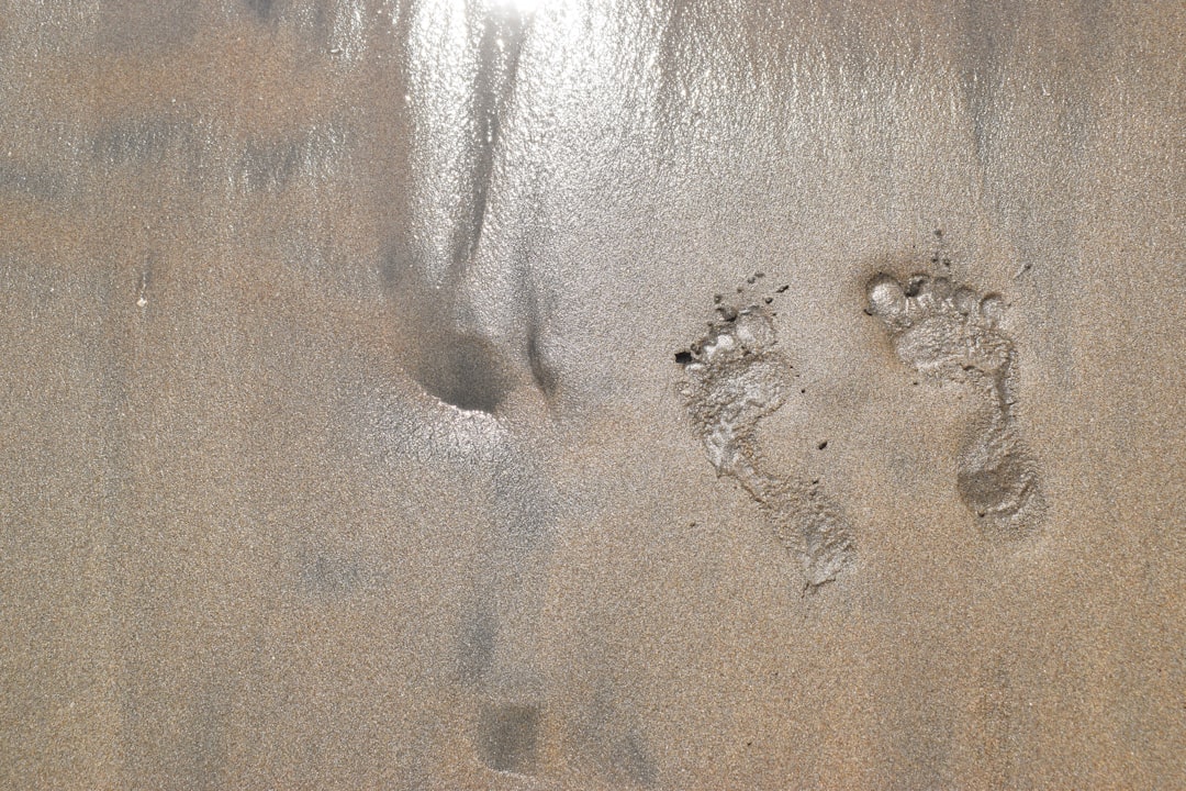 Two footprints in the sand of a beach